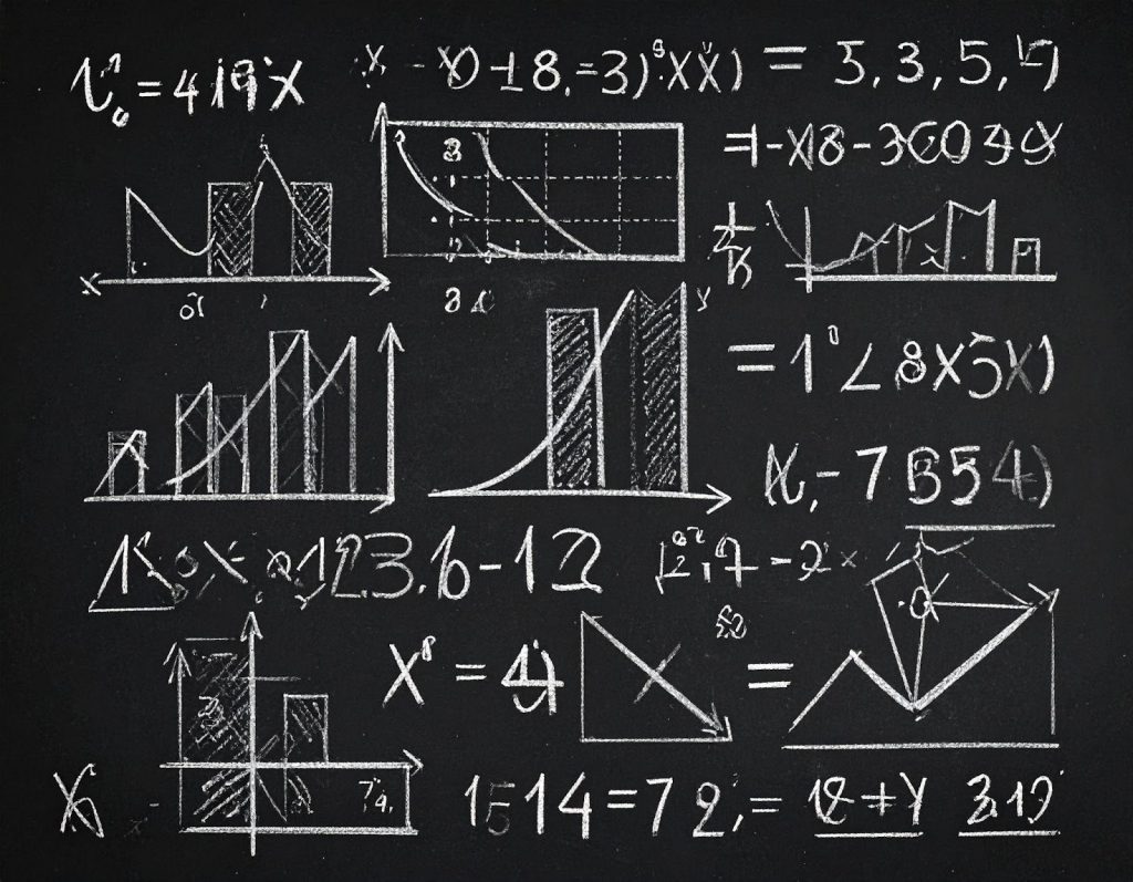 Imagem em fundo preto com várias expressões numéricas escritas com giz branco. Fim da descrição.